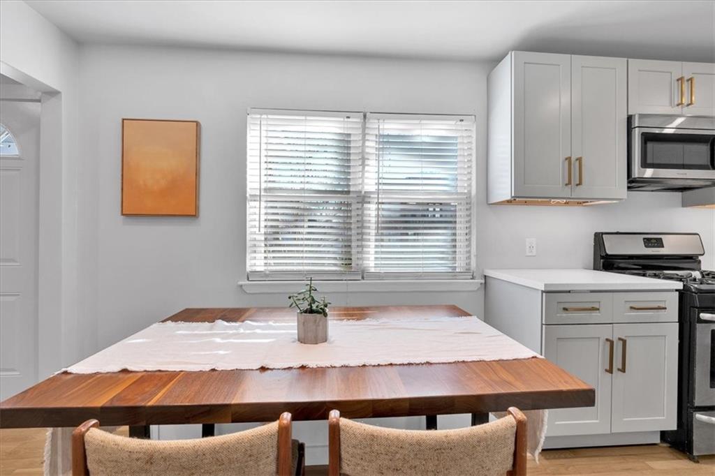 1520 Foote Street Northeast Atlanta, GA 30307 - Photo 11 of 39 a kitchen with a stove a sink cabinetry and dining table