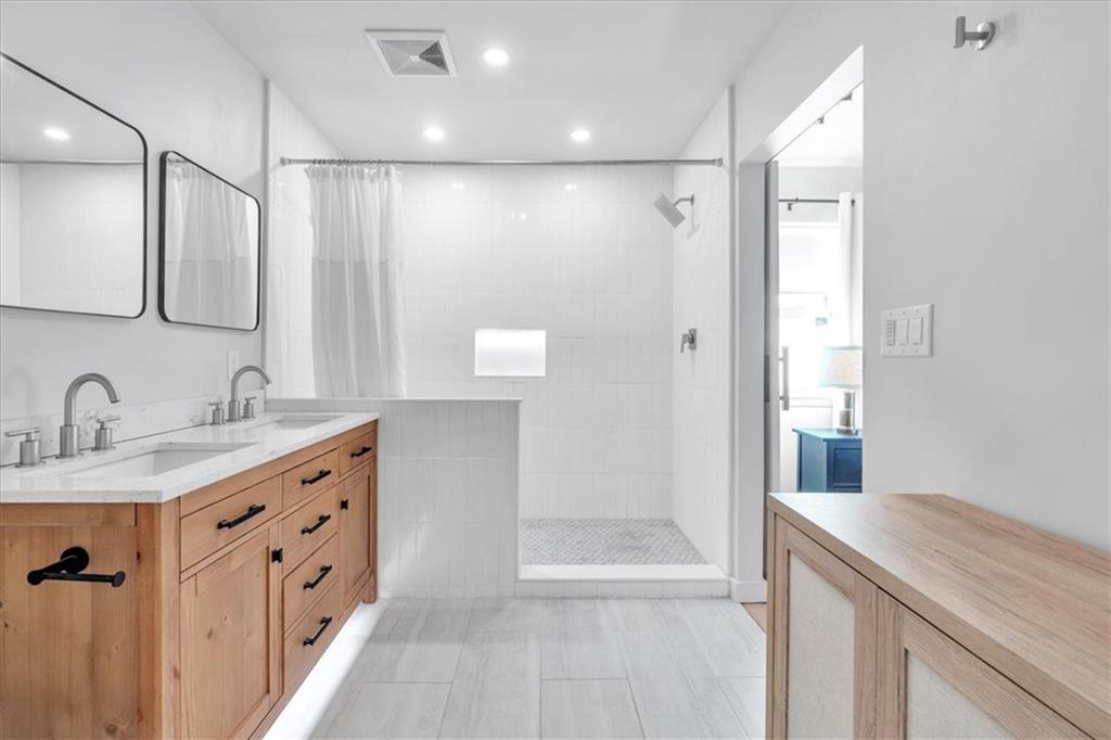 1520 Foote Street Northeast Atlanta, GA 30307 - Photo 22 of 39 a bathroom with a granite countertop sink a mirror and a shower