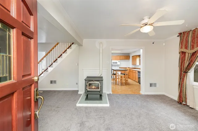 a view of a livingroom with furniture staircase and a ceiling fan
