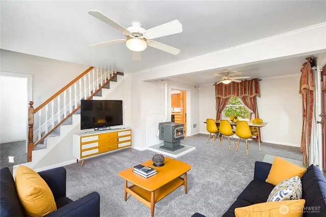 a living room with furniture flat screen tv and a large window