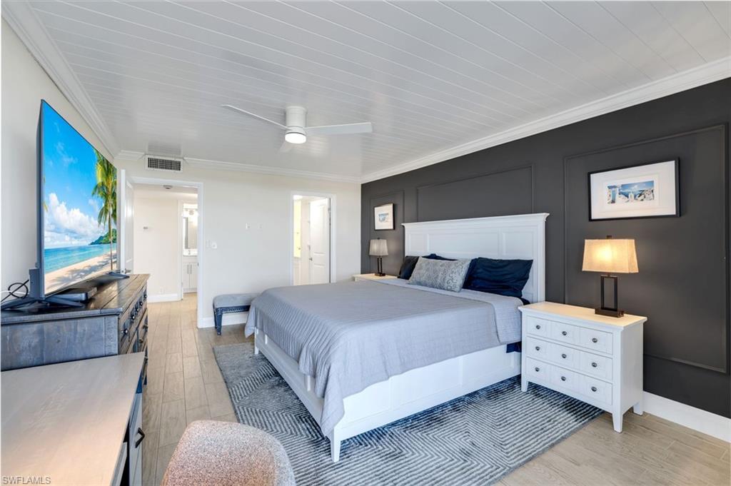 5 Bluebill Avenue, Unit 506 Naples, FL 34108 - Photo 11 of 25 a spacious bedroom with a bed and a flat screen tv
