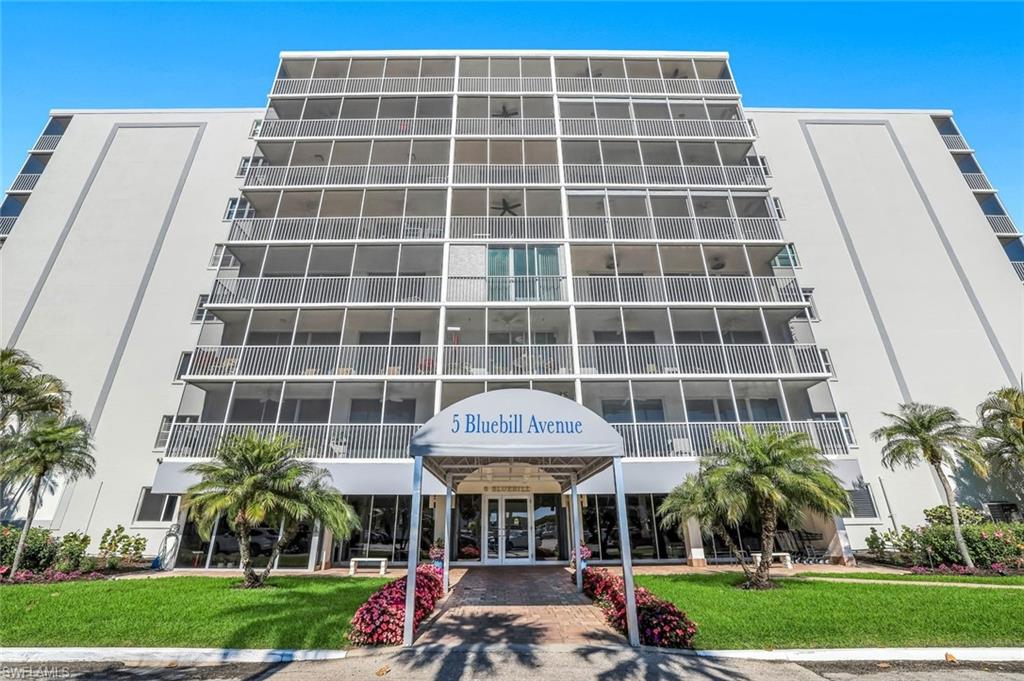 5 Bluebill Avenue, Unit 506 Naples, FL 34108 - Photo 22 of 25 a front view of a building with a garden and plants