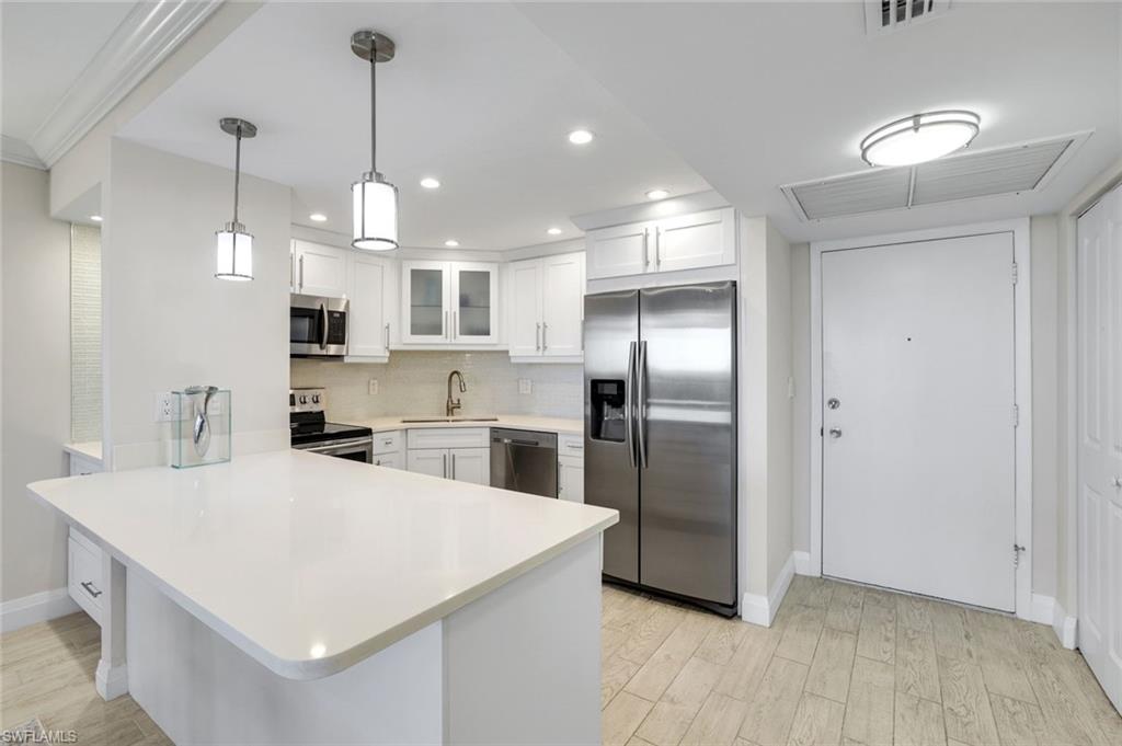 5 Bluebill Avenue, Unit 506 Naples, FL 34108 - Photo 6 of 25 a kitchen with stainless steel appliances a refrigerator sink and microwave