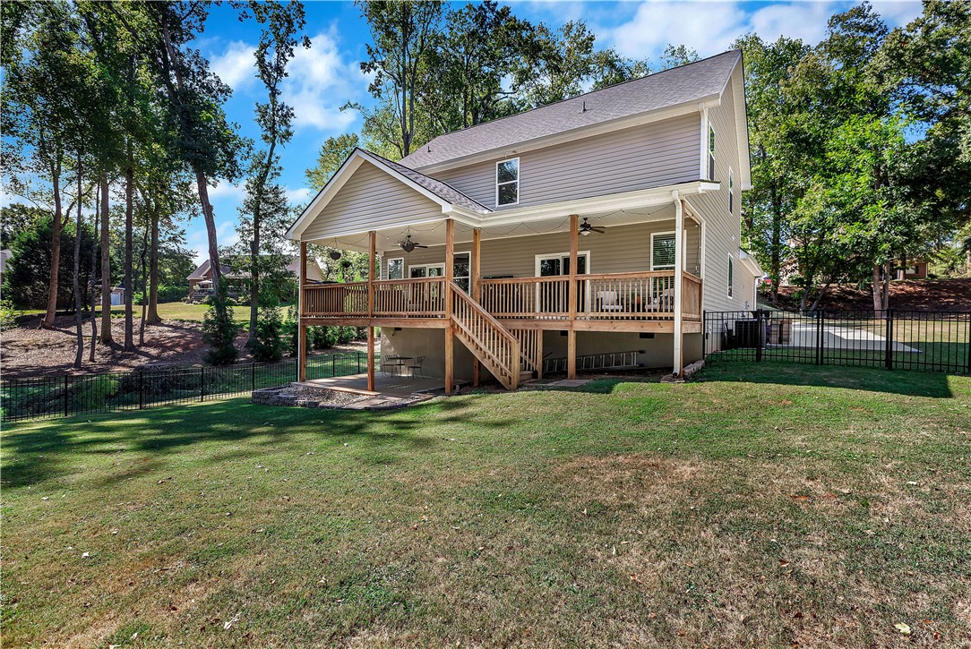 3004 Cobbs Way Anderson, SC 29621 - Photo 31 of 46 An elevated wooden deck overlooks a grassy backyard enclosed by metal fencing.