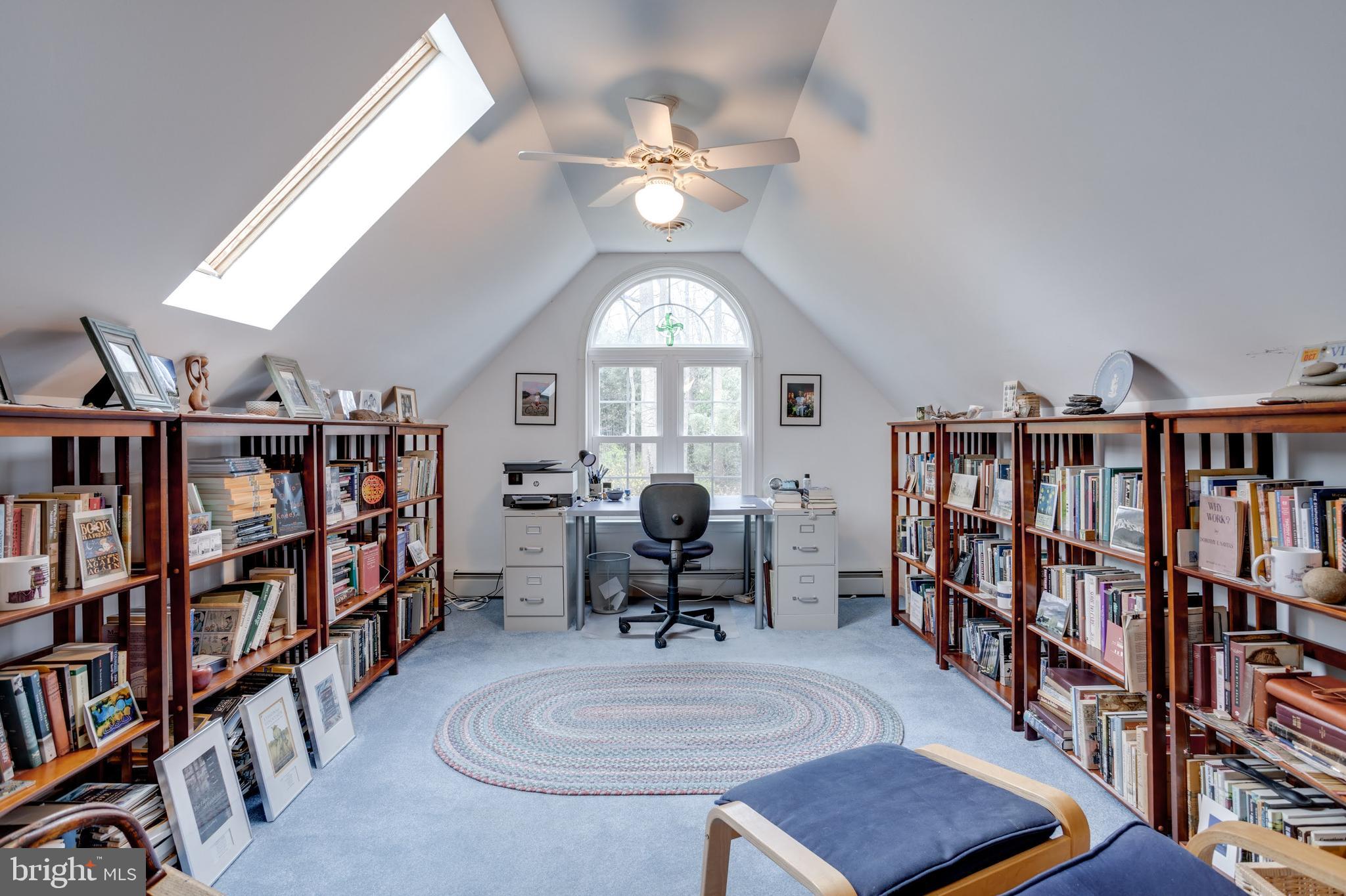 8901 Burke Road Burke, VA 22015 - Photo 39 of 63 a living room with lots of books table chairs a book shelf and a window