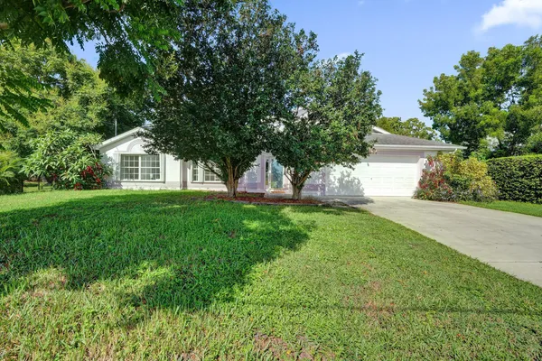 a front view of a house with a yard and trees
