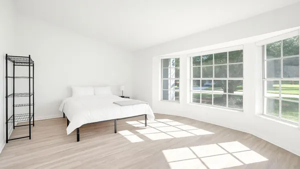 a bedroom with a bed and a large window