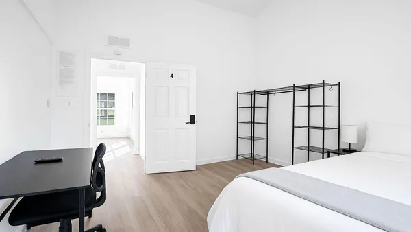 a bedroom with a bed chair and a window