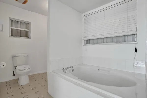 a white bath tub sitting next to a toilet