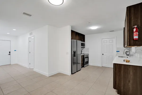 a hallway with a refrigerator and a sink