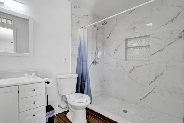 a bathroom with a shower a toilet and sink