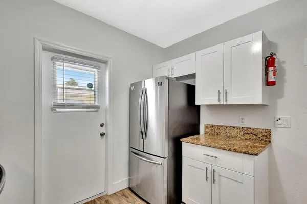 a kitchen with stainless steel appliances granite countertop a refrigerator a microwave and cabinets