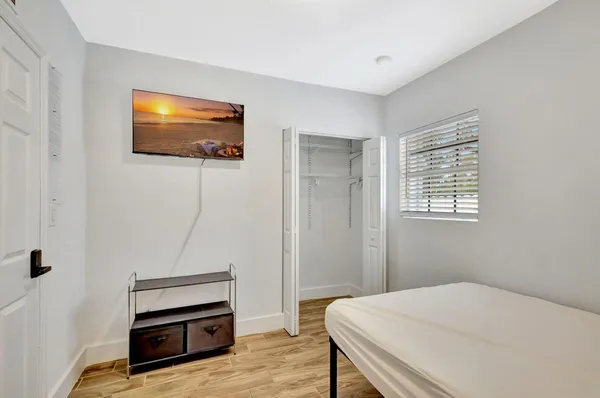 a bedroom with a bed and a flat screen tv