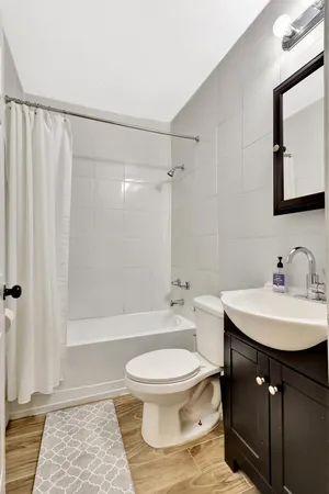 a bathroom with a sink toilet a mirror and shower