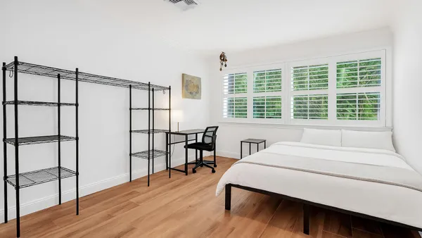 a bedroom with a bed window and a table