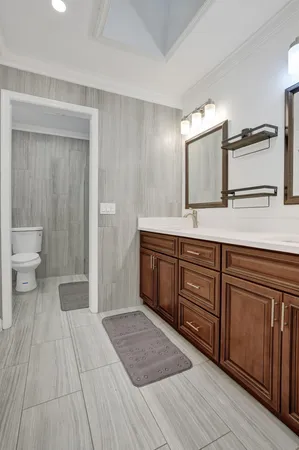 a spacious bathroom with a granite countertop sink and a mirror