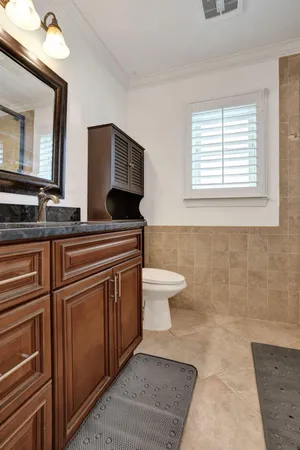 a bathroom with a toilet a sink and mirror