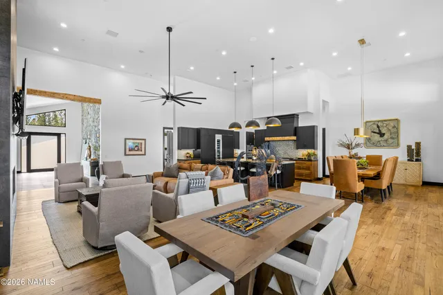 a living room with lots of furniture kitchen view and a chandelier
