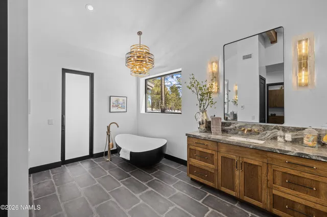 a spacious bathroom with a granite countertop sink and a mirror