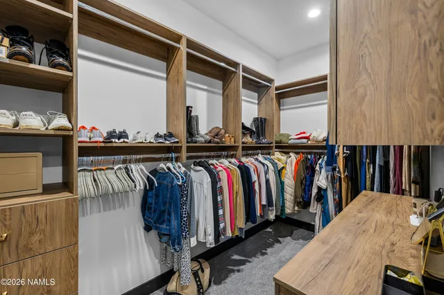a view of walk in closet with clothes and shoes