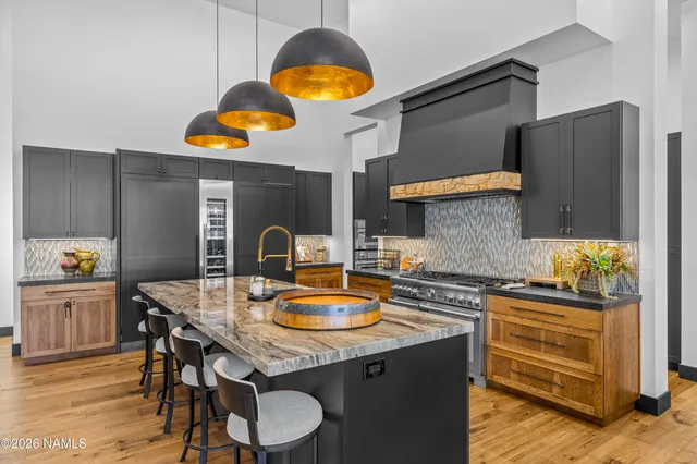 a kitchen with a sink a stove and chairs with wooden floor