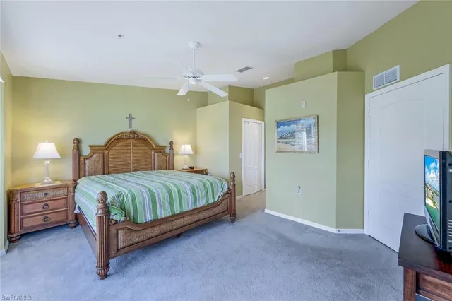 a bedroom with a bed and a flat tv screen on dresser