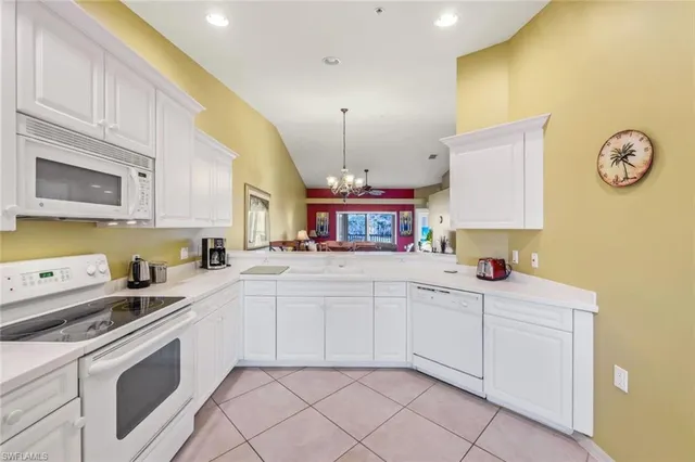 a kitchen with granite countertop white cabinets and white appliances