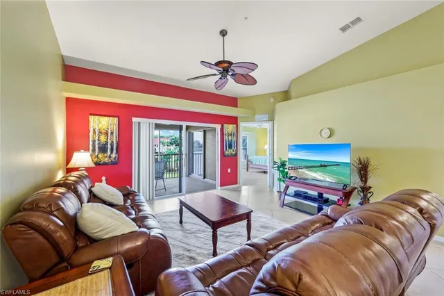 a living room with furniture a floor to ceiling window and a flat screen tv