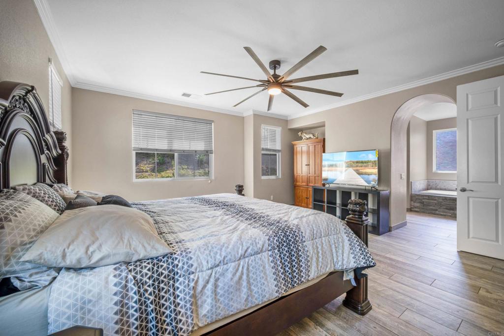 2781 Rambling Vista Road Chula Vista, CA 91915 - Photo 21 of 50 a bedroom with a large bed a chandelier and windows