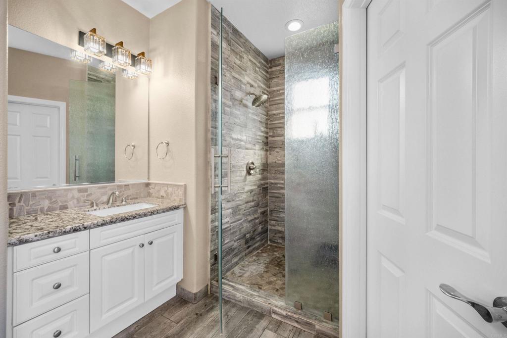 2781 Rambling Vista Road Chula Vista, CA 91915 - Photo 22 of 50 a bathroom with a granite countertop sink a mirror and shower