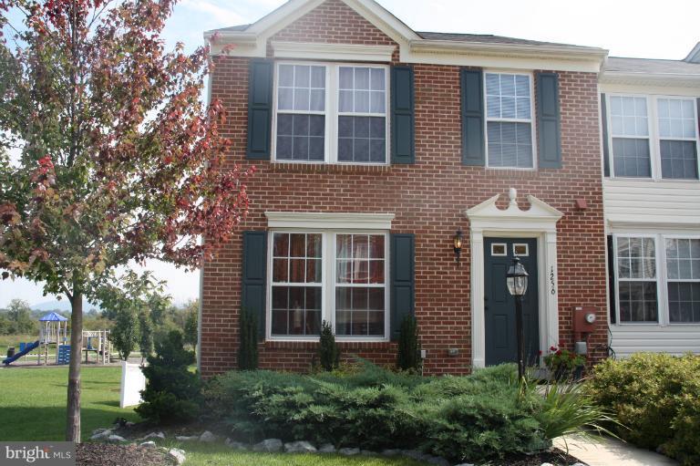 a view of a brick house with a large windows and a large tree
