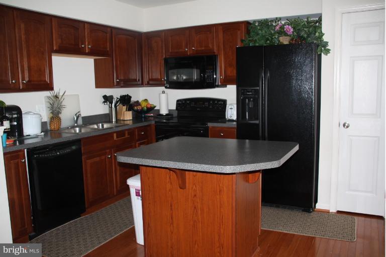 1256 Steed Street Ranson, WV 25438 - Photo 4 of 16 a kitchen with a sink a microwave a refrigerator and cabinets