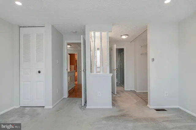 an empty room with closet and a bathroom