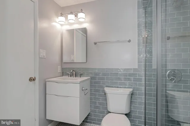 a bathroom with a sink a toilet and mirror