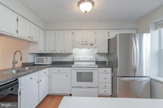 a kitchen with appliances a sink and cabinets