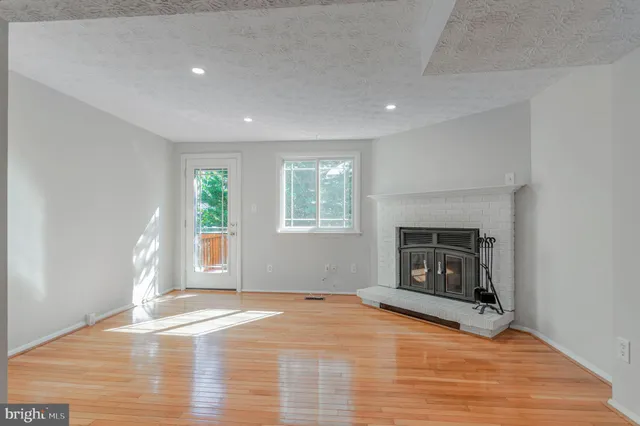 a view of empty room with wooden floor and fireplace