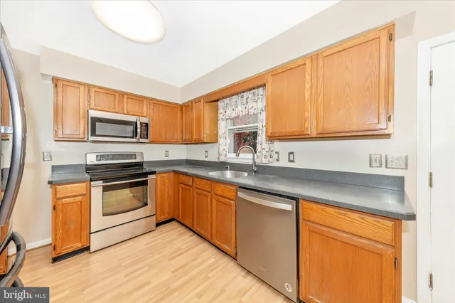 a kitchen with granite countertop a refrigerator and a sink