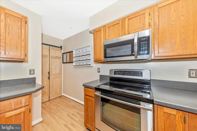 a kitchen with stainless steel appliances granite countertop a sink window and cabinets