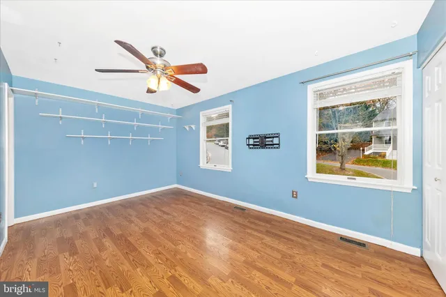 a view of room with wooden floor and a ceiling fan