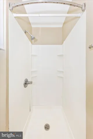 a view of a room with a ceiling fan and hardwood floor