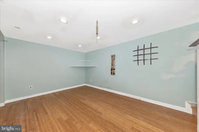 a view of a hallway with stainless steel appliances a refrigerator and a window