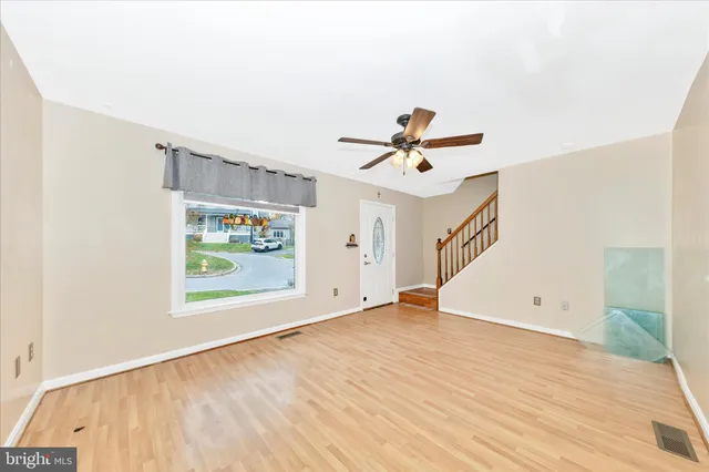 a view of a livingroom with wooden floor and a ceiling fan