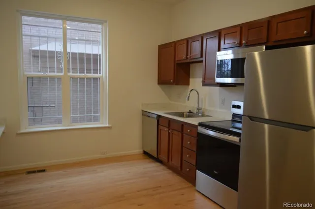 a kitchen with stainless steel appliances granite countertop a refrigerator stove and sink