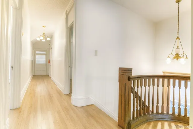 a view of a hallway with wooden floor and staircase