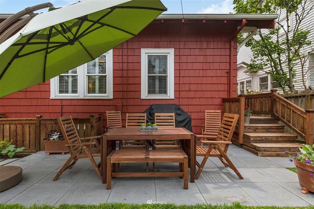 a view of a chair and table in backyard of the house