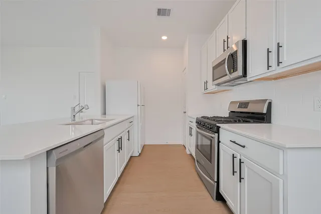 a kitchen with granite countertop a sink and cabinets