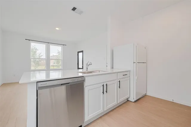 a kitchen with white cabinets and a sink