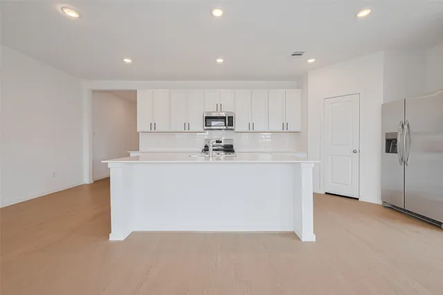 a kitchen with kitchen island white cabinets and white appliances