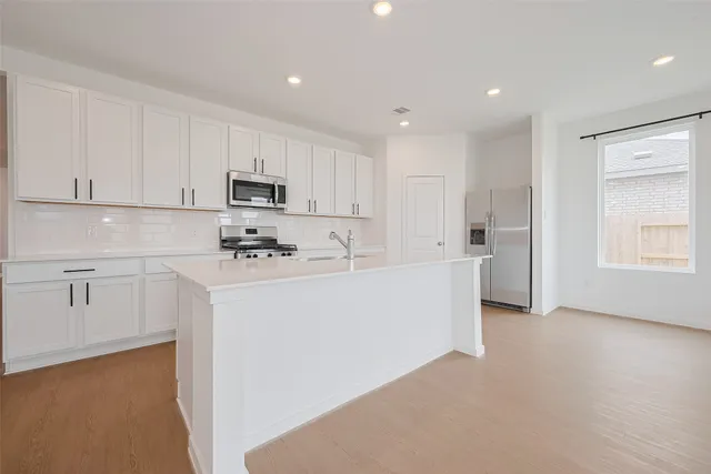 a kitchen with kitchen island white cabinets and white appliances