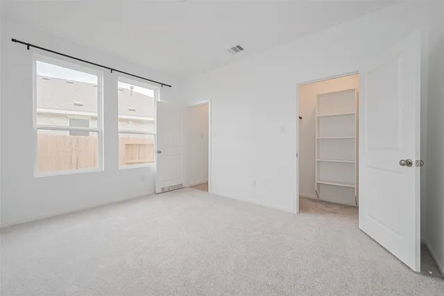 an empty room with windows and closet